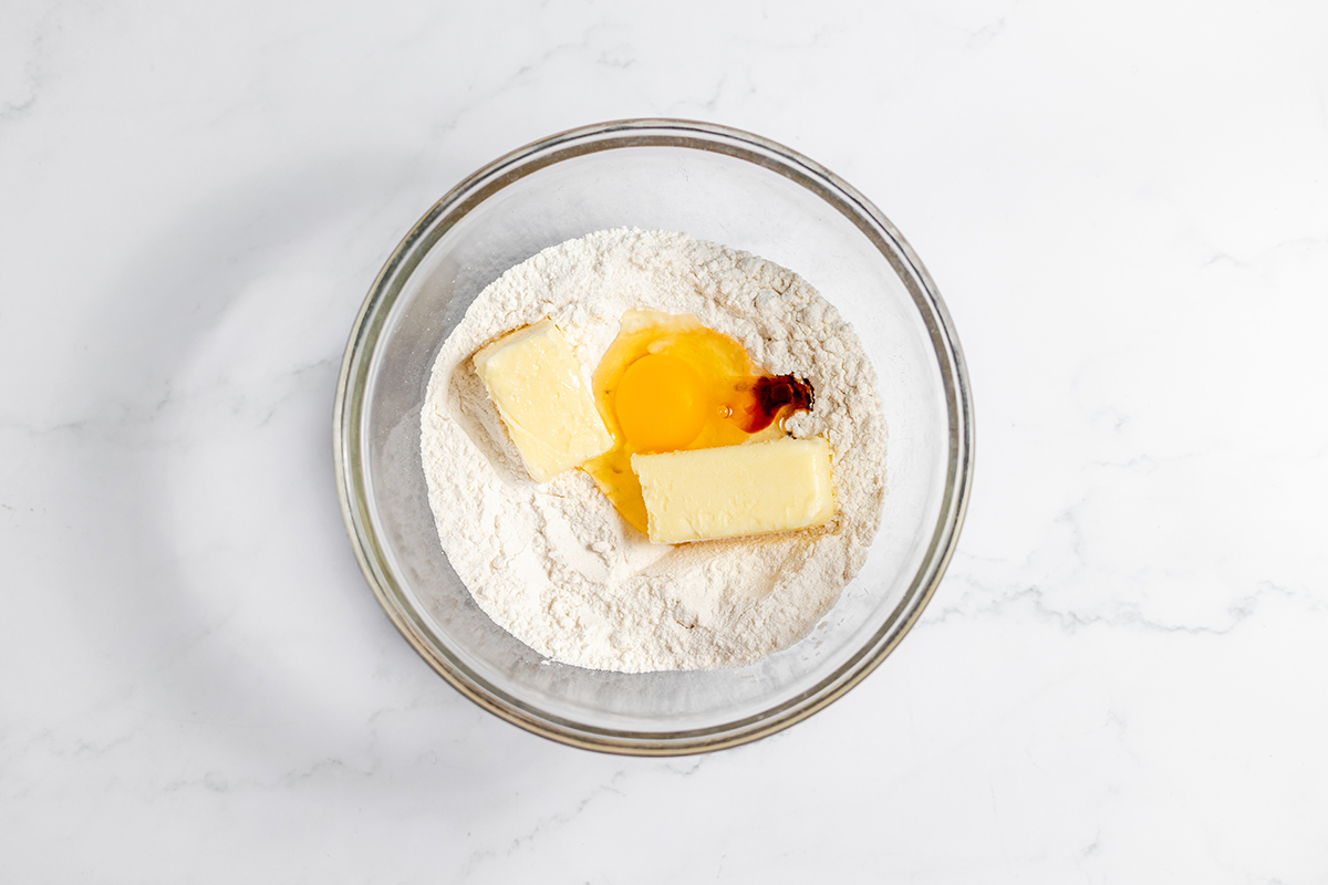 Butter, eggs and vanilla added to dry ingredients in glass mixing bowl.
