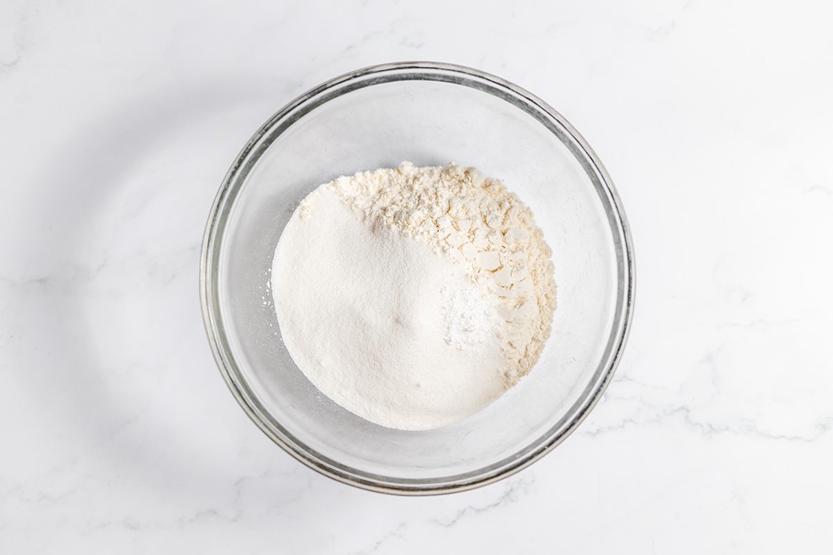 Flour, sugar, baking powder and salt added to glass mixing bowl.