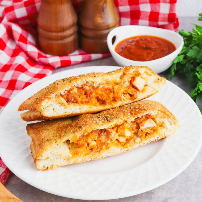 Two slices of Chicken Parmesan Stromboli on white plate.