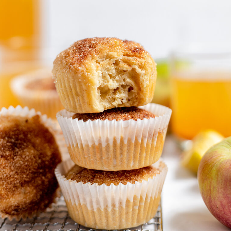 Apple Cider Muffins stacked together on wire rack.
