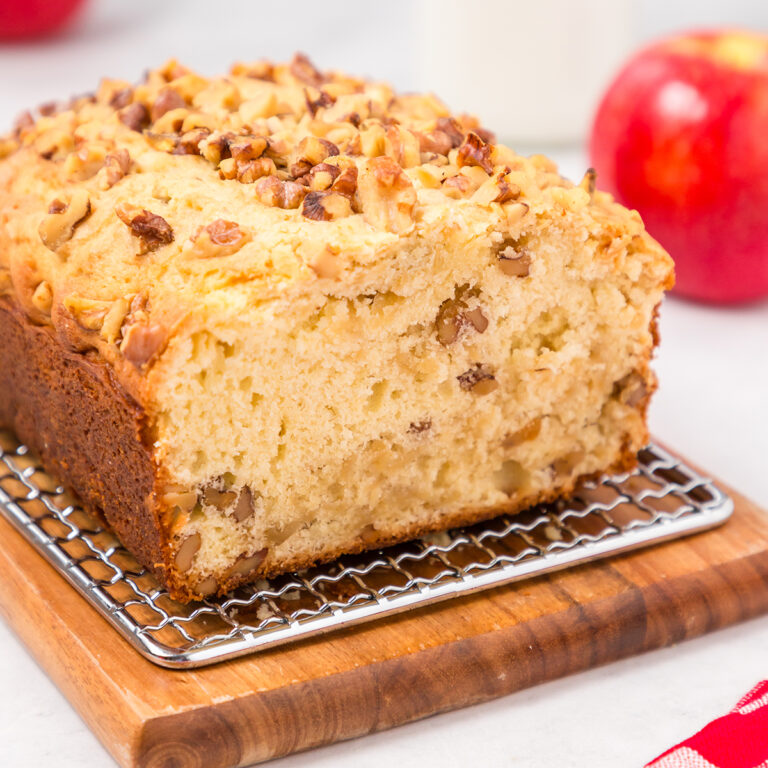 Apple Walnut Bread on wire rack on top of wooden serving board.