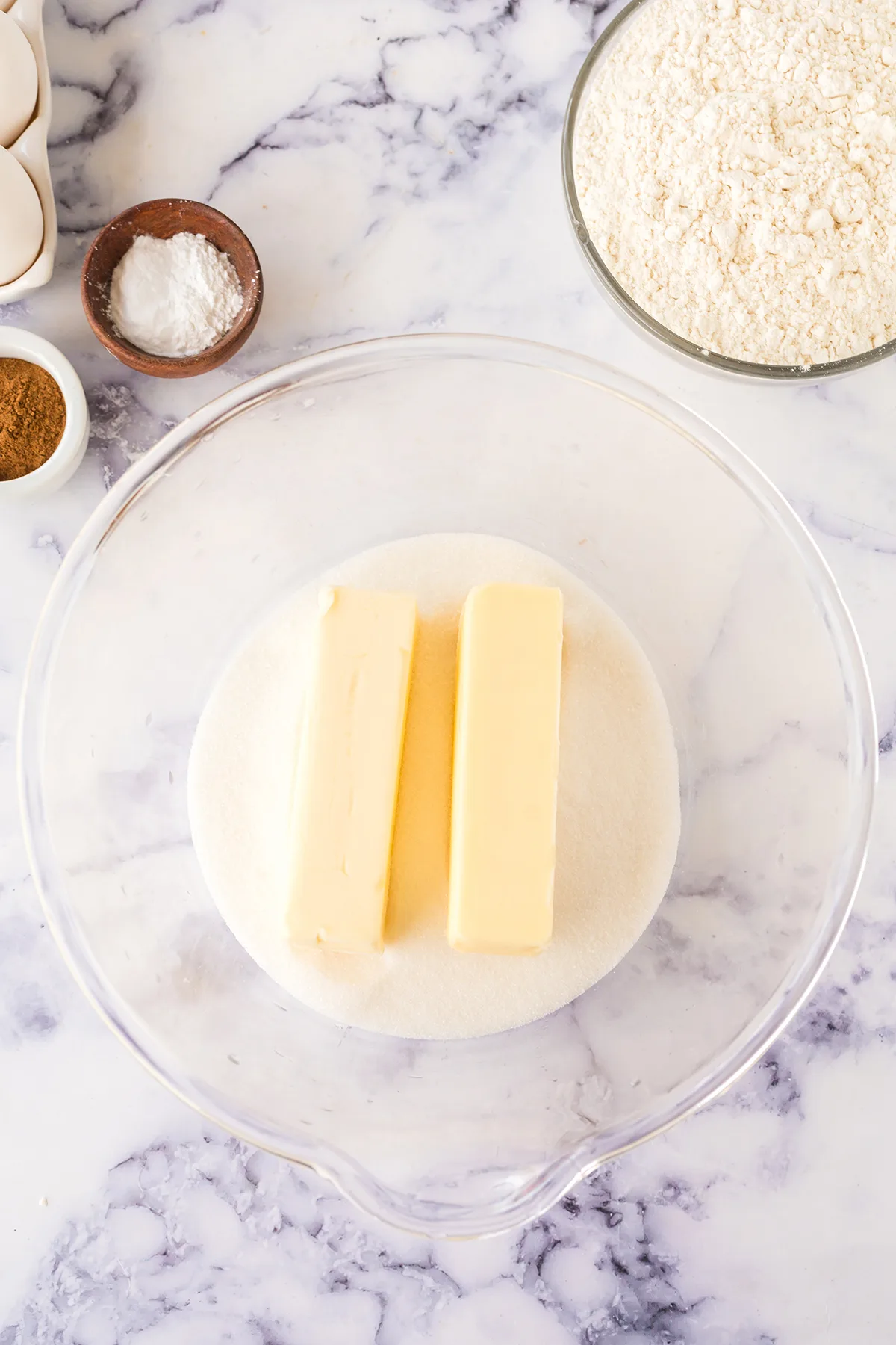 Butter and sugar in glass mixing bowl.
