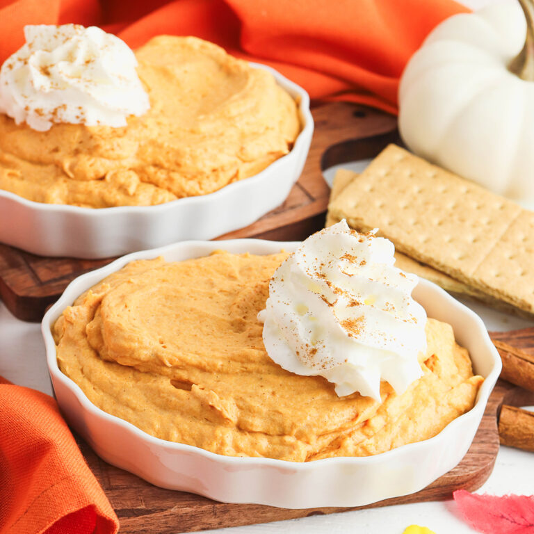 Pumpkin Fluff Dip in round white serving bowl topped with whipped cream.