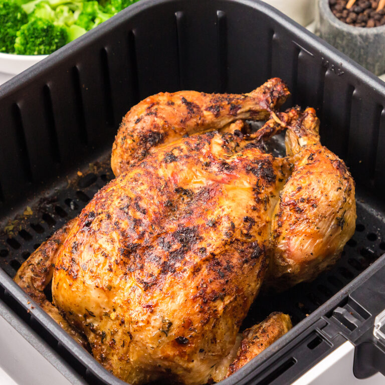 Cooked Whole Chicken in air fryer basket.