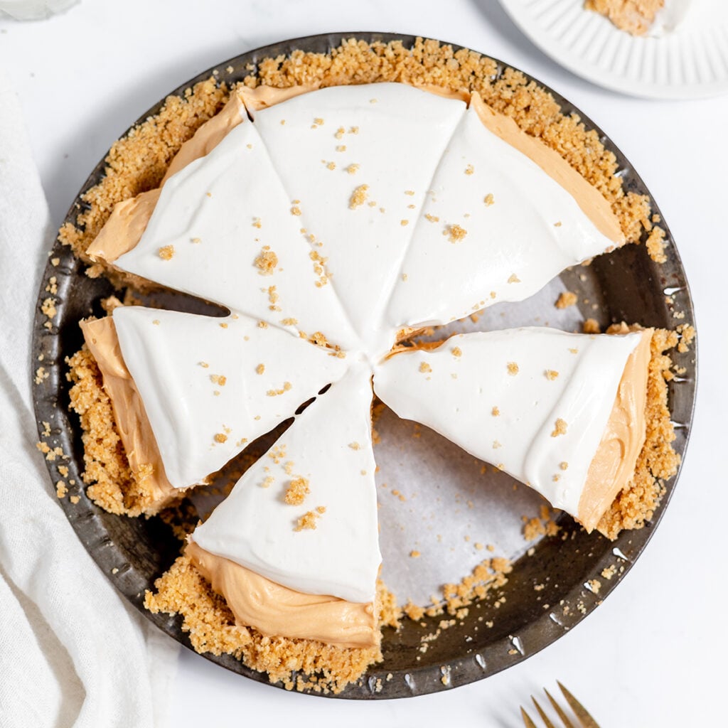 Butterscotch Pie cut into slices on a pie plate.