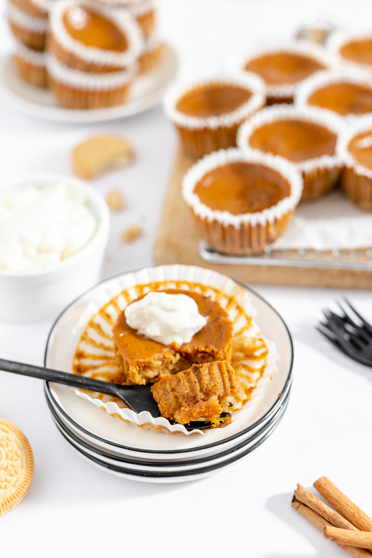Mini pumpkin pie on white plate and more on wire cooling rack.