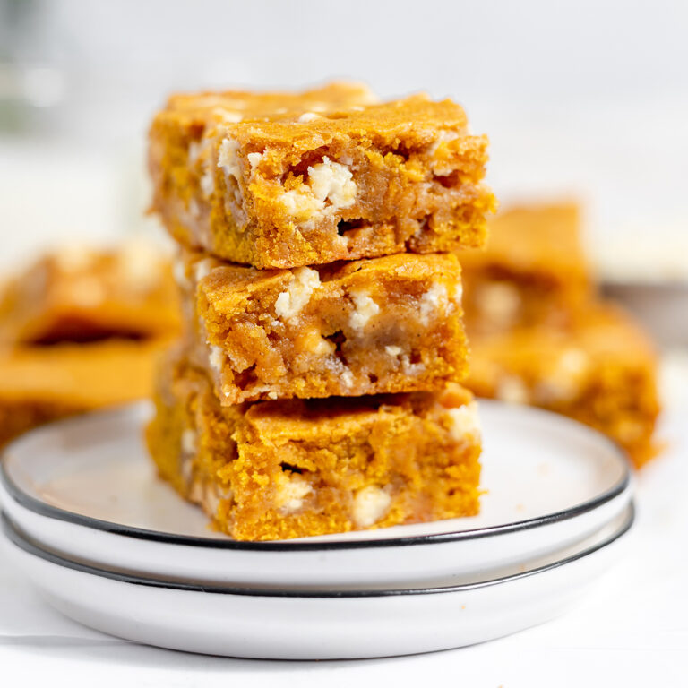 Three Pumpkin Blondies stacked on white plate.