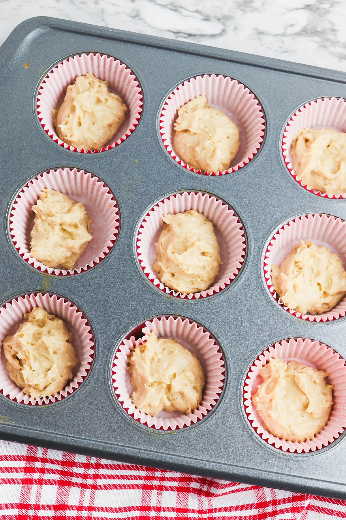 A tablespoon of batter is added to the liners in the muffin pan.
