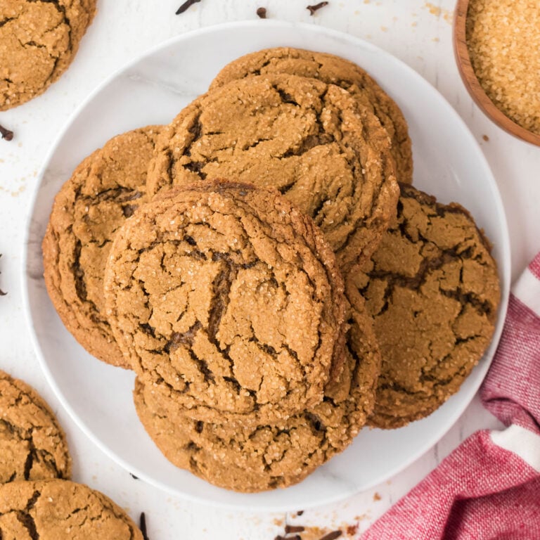 Molasses Spice Cookies stacked on a white plate.