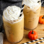 Two glasses of Pumpkin Cream Cold Brew with a black and white straw.