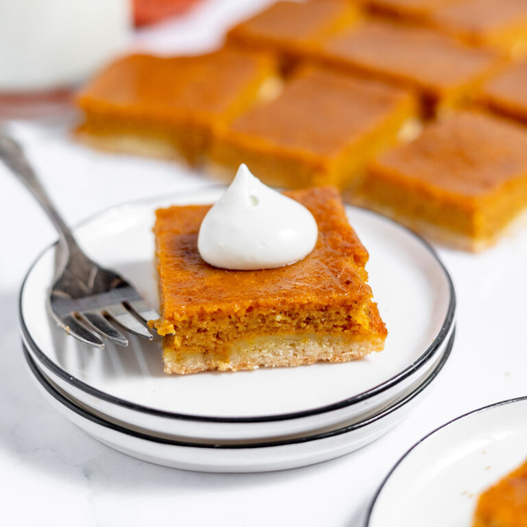 Pumpkin Pie Bar with dollop of whipped cream on plate.
