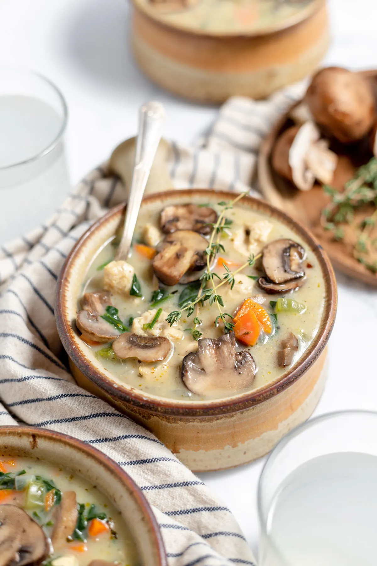 Chicken and Mushroom Soup served in a tan bowl with a spoon.