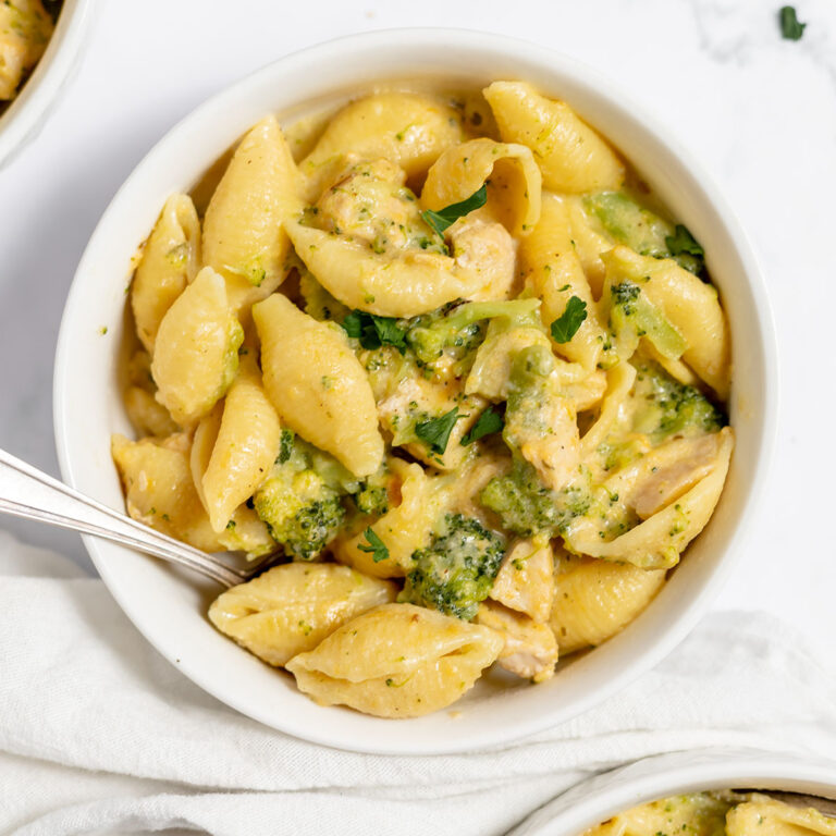 Serving of chicken broccoli pasta in a white bowl.