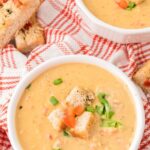 Cheese soup served in a bowl topped with croutons.