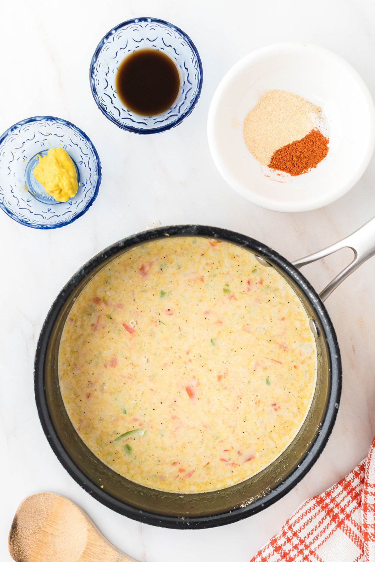 Flour, milk, and heavy cream added to vegetables in the saucepan