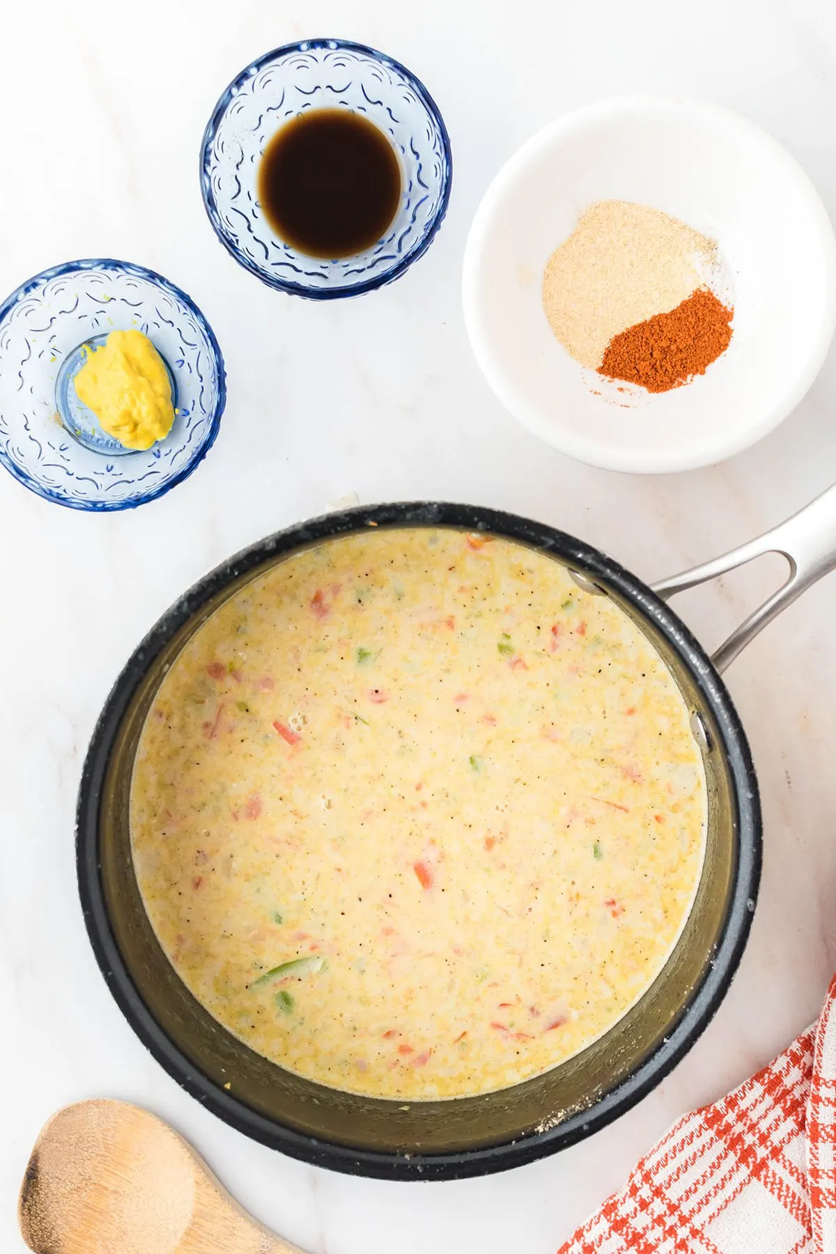 Flour, milk, and heavy cream added to vegetables in the saucepan