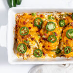 Jalapeno Popper Chicken Baked in white baking dish.