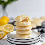 Four Lemon Ricotta Cookies stacked on white plate.