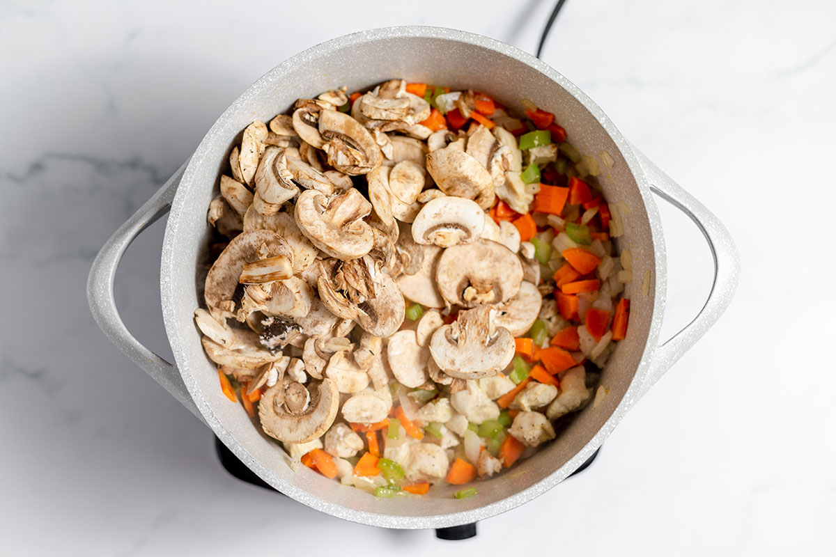 Mushrooms added to chicken and vegetables in the large pot.