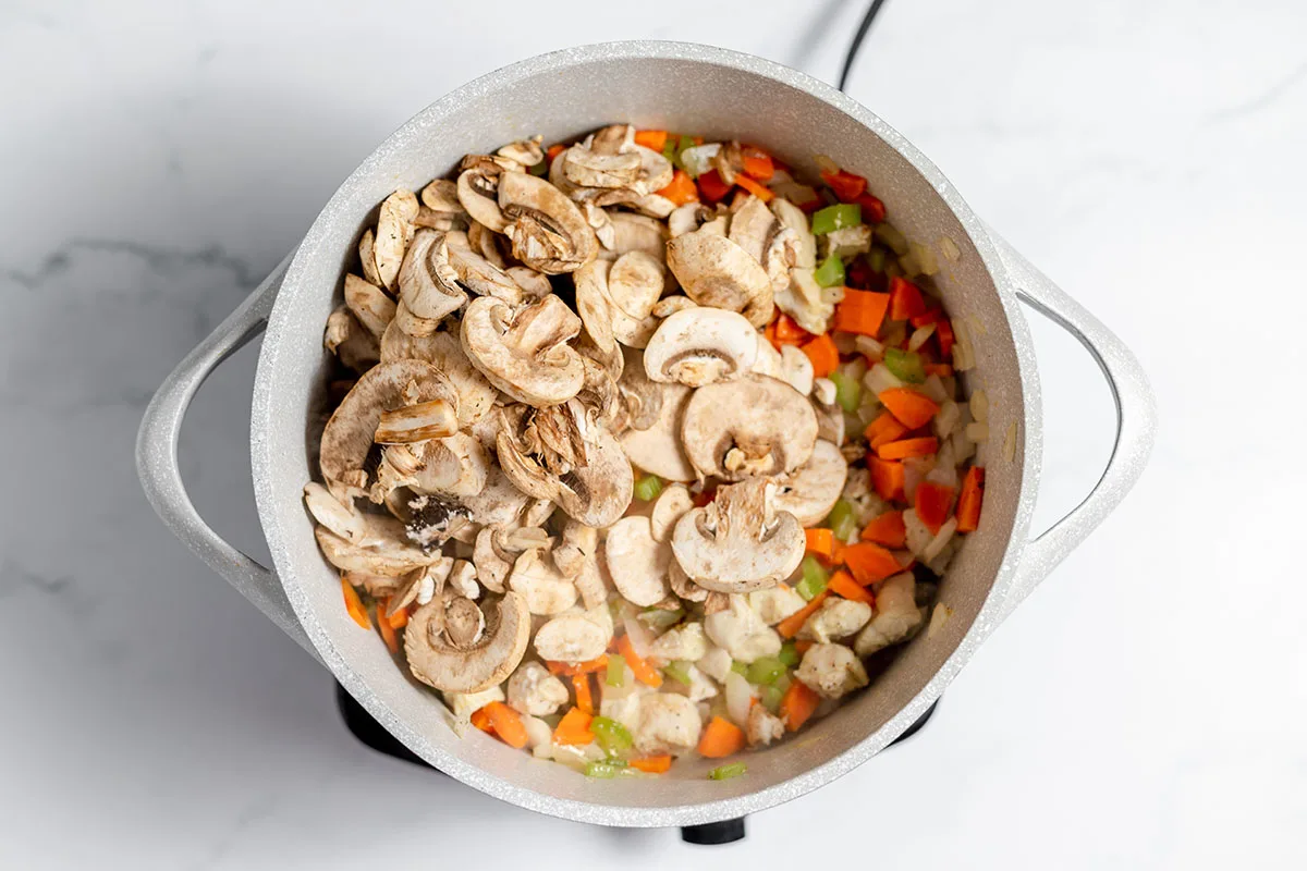 Mushrooms added to chicken and vegetables in the large pot.