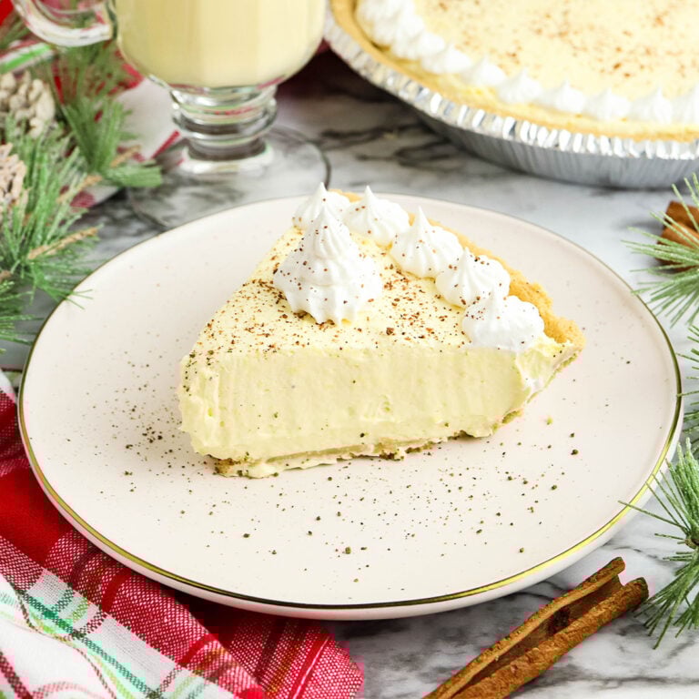 Slice of Eggnog Pie topped with whipped cream on a plate.