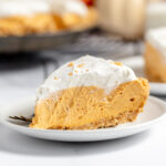 A slice of Pumpkin Cheesecake on a white plate.