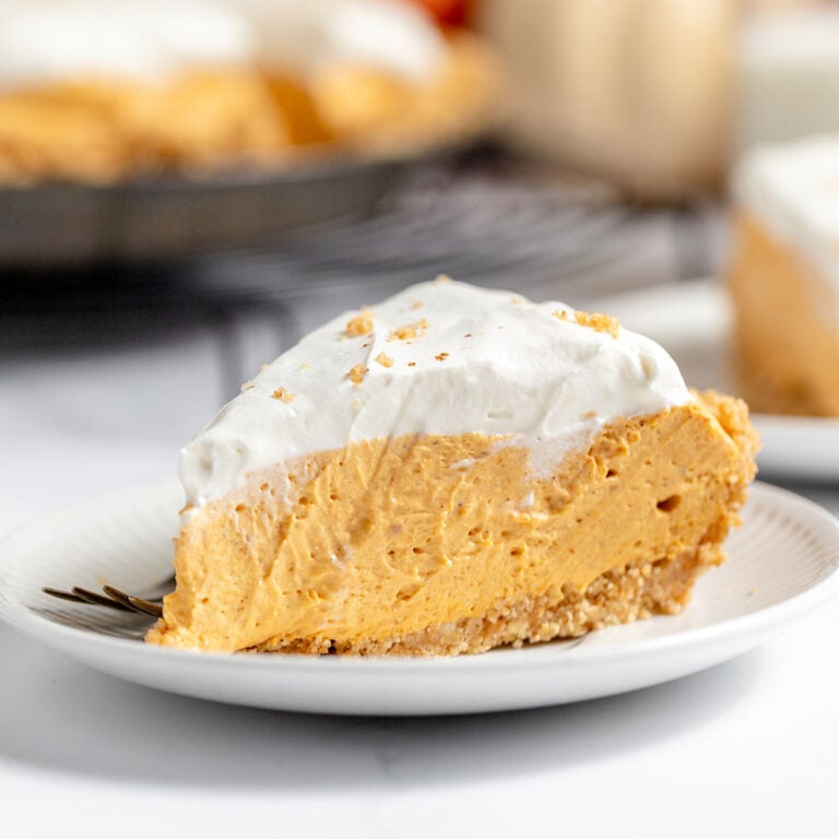 A slice of Pumpkin Cheesecake on a white plate.