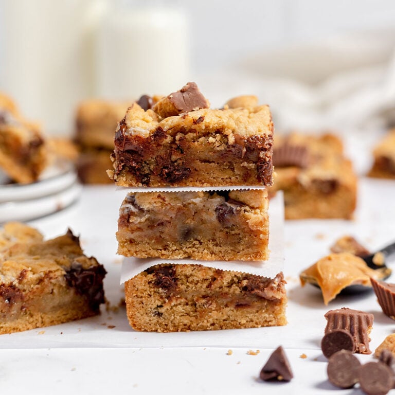 Three Peanut Butter Chocolate Chip Bars stacked together with parchment paper between them.