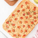 Tomato Focaccia Bread set out on a white wooden counter.
