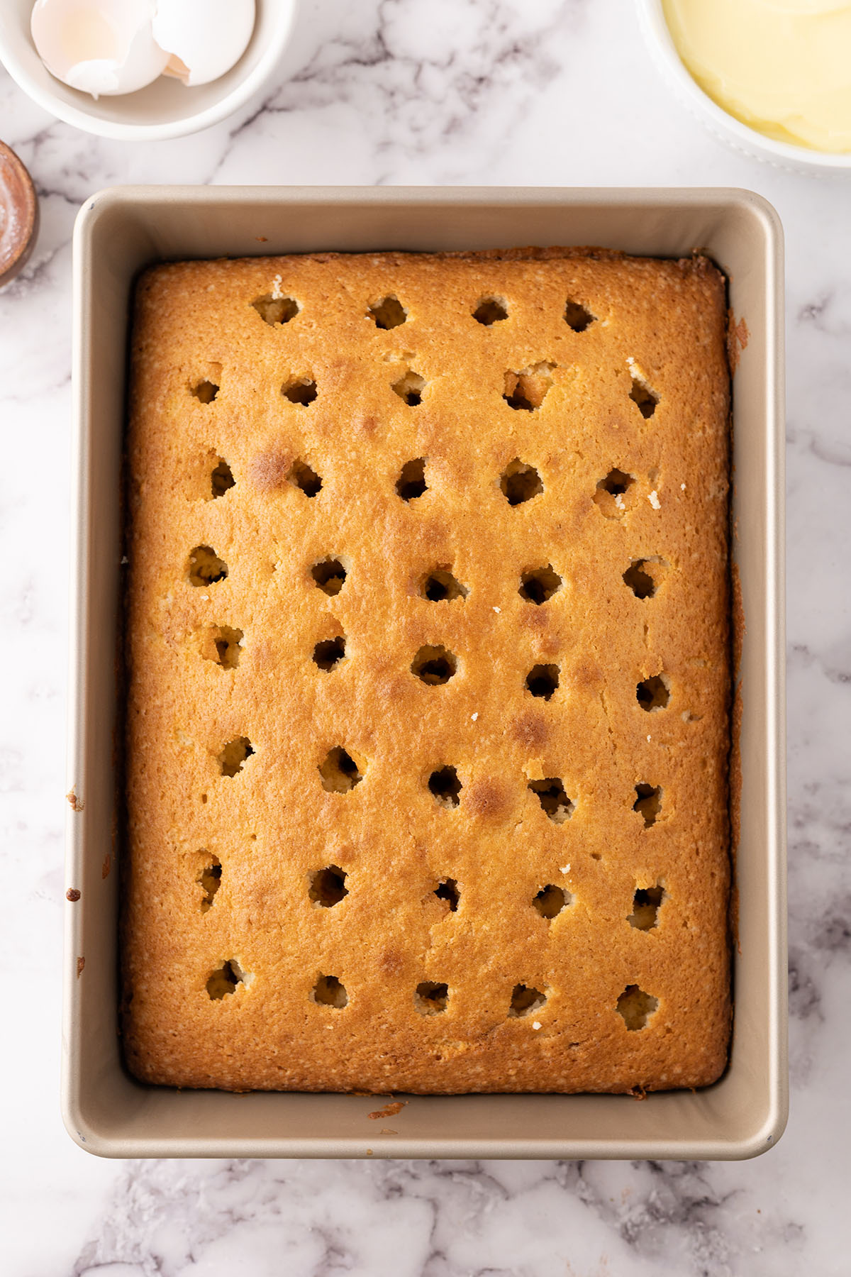 Baked cake with holes poked in the top.