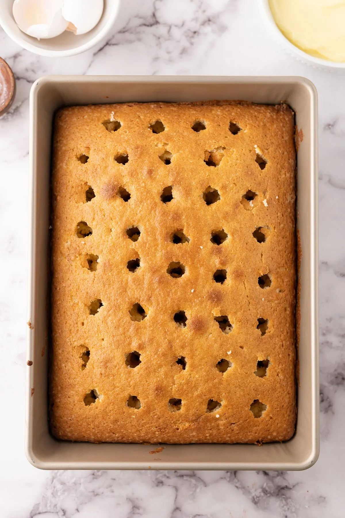Baked cake with holes poked in the top.