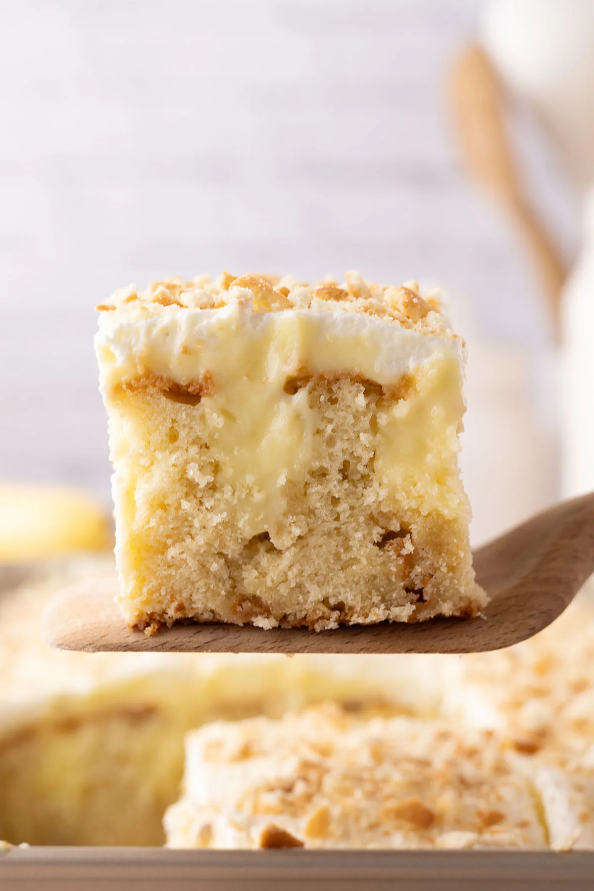 Slice of Banana Pudding Cake on a wooden serving spoon.