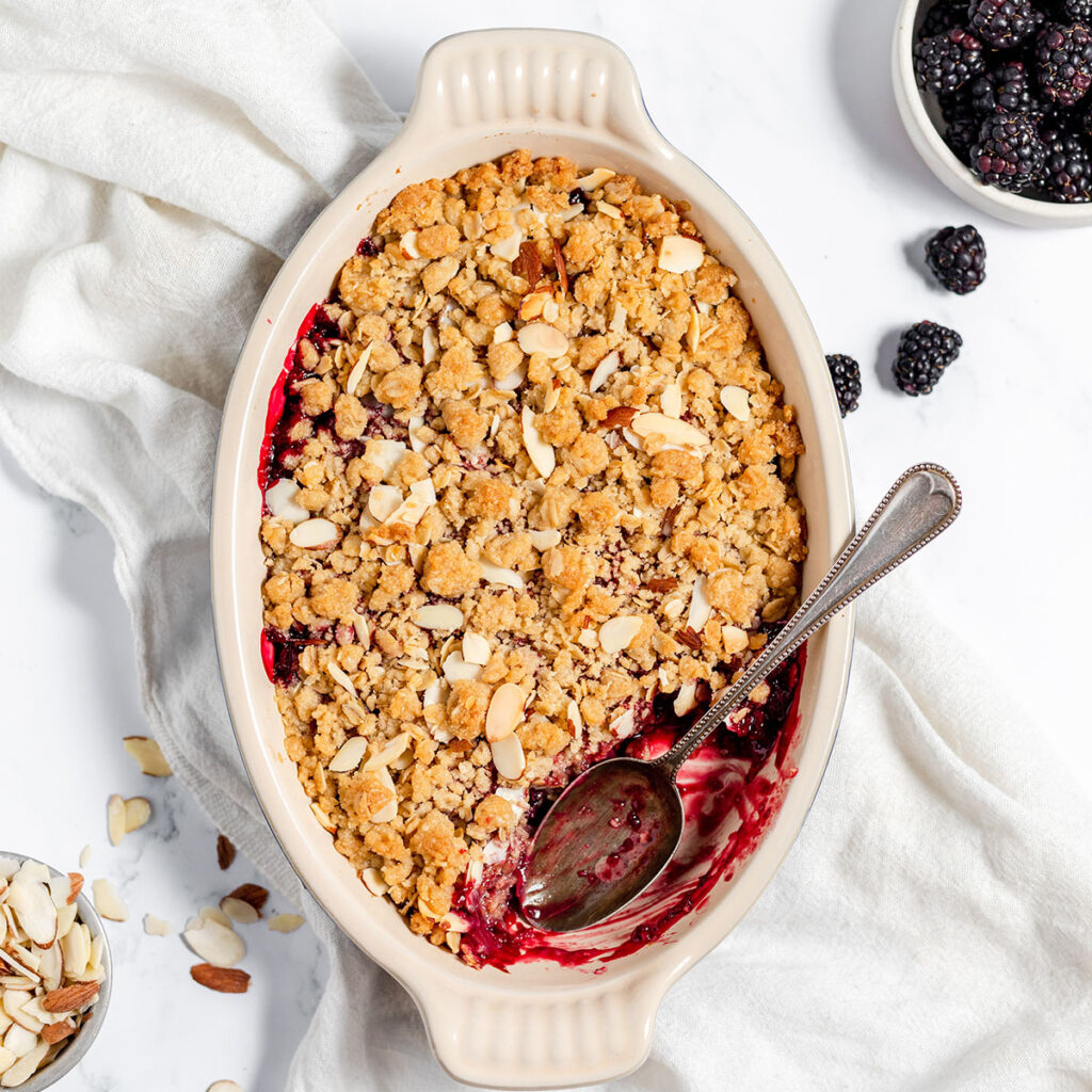 Blackberry Crisp in a baking dish with a spoon.