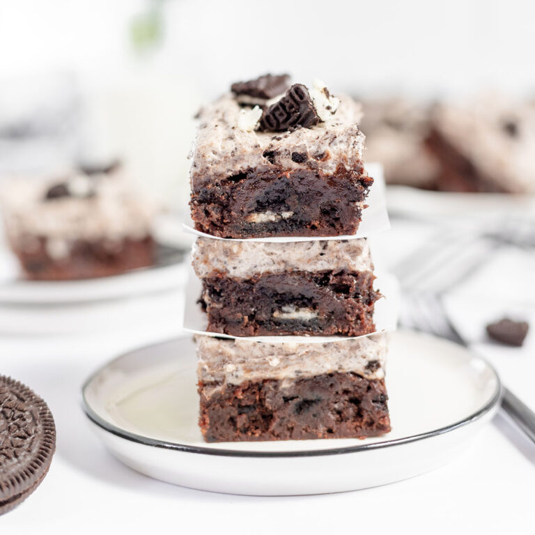 Cookies and cream brownies stacked on a white plate.