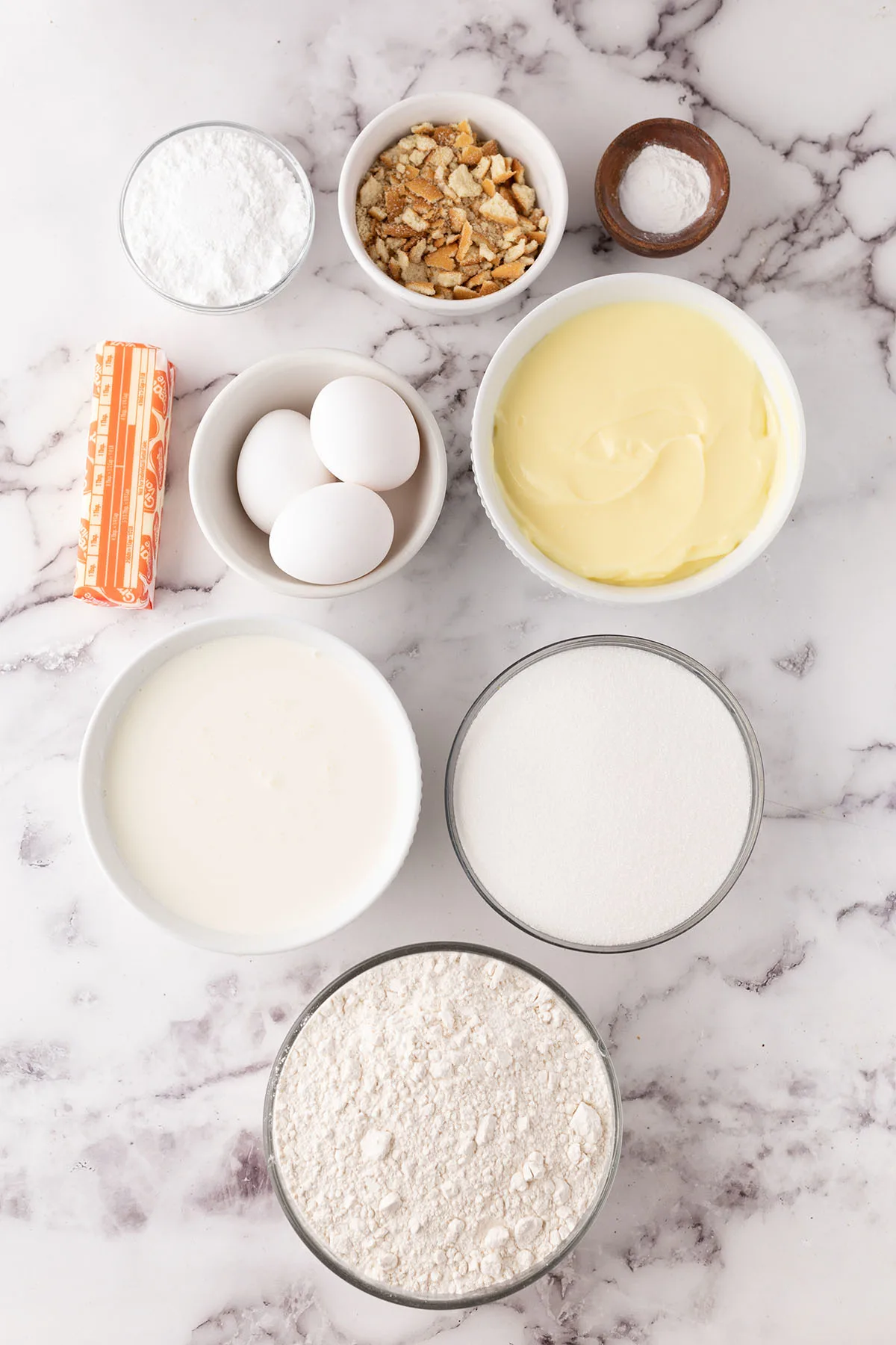 Ingredients to make banana pudding poke cake set out on the counter.