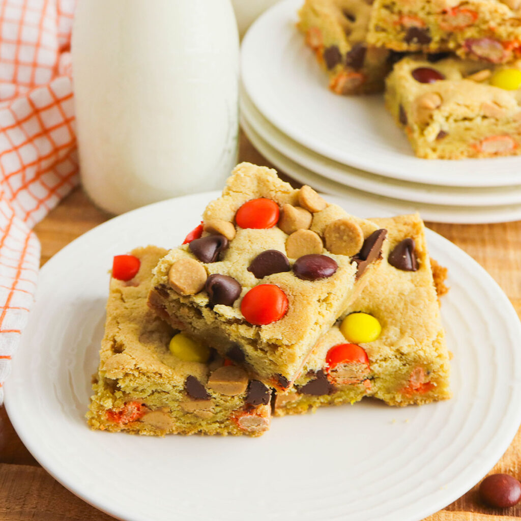 Three Reese&rsquo;s Pieces Bars stacked on a plate.