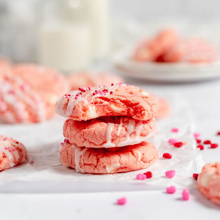 Strawberry Cake Mix Cookies stacked on parchment paper.