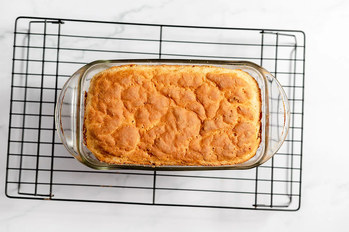 Baked English Muffin Bread in baking pan on a wire rack.