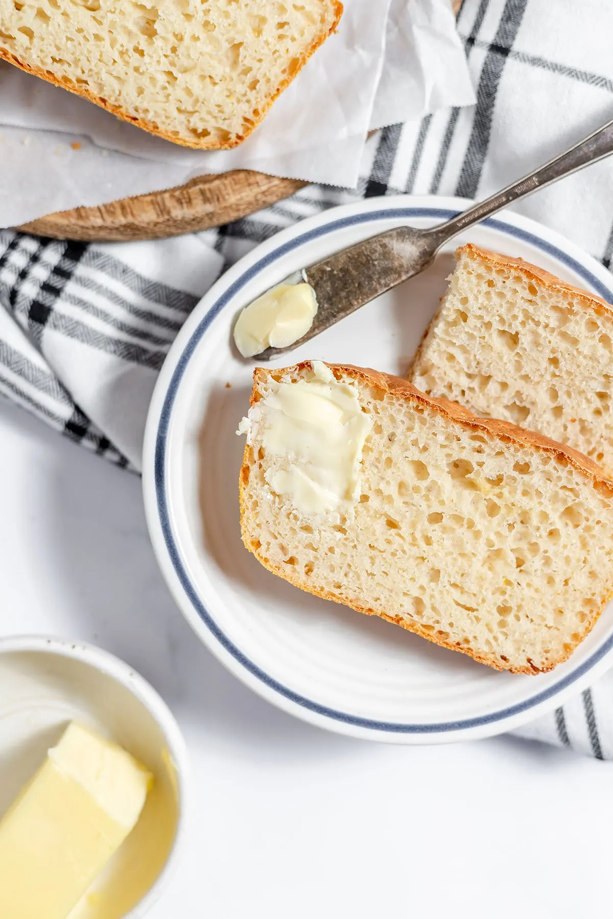 Slice of English Muffin Bread on a plate with a dab of butter.