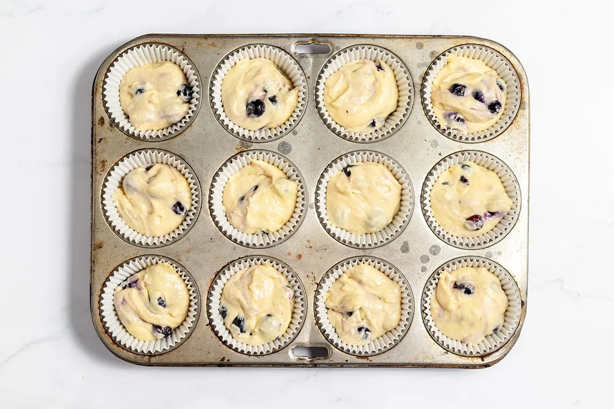 Blueberry Lemon Muffin batter in a muffin pan.