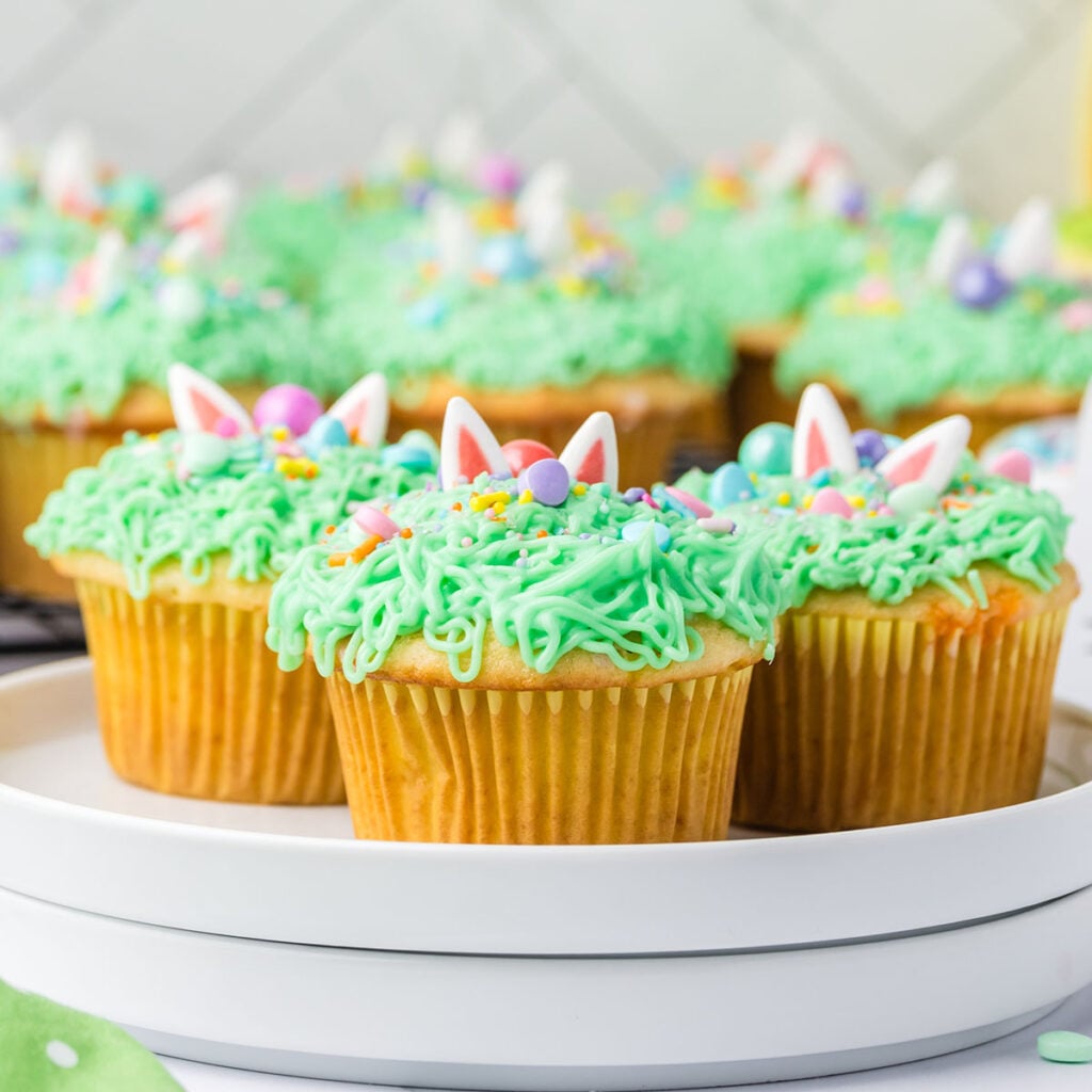 Three Easter Bunny Cupcakes on a round white plate.
