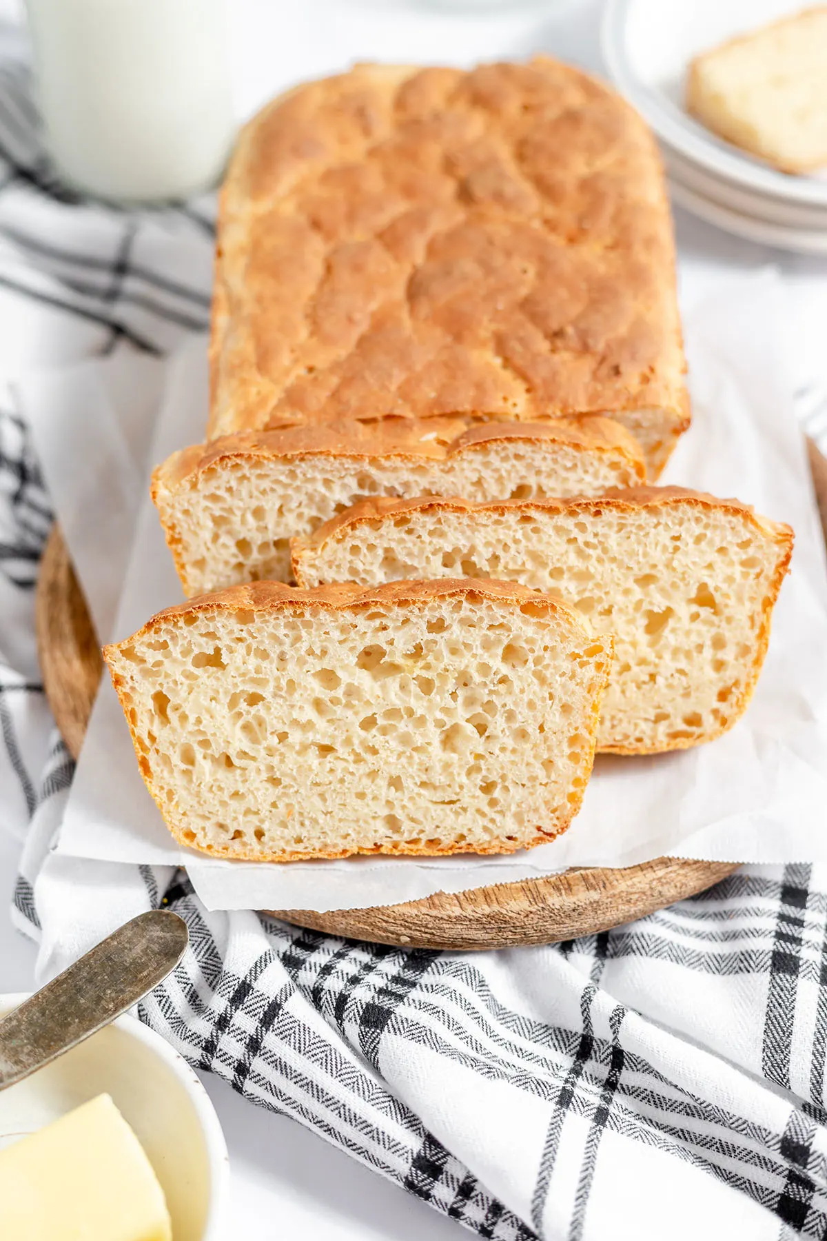 English Muffin Bread with three pieces sliced on a wood serving board.