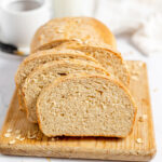 Honey Oat Bread sliced on a wooden serving board.