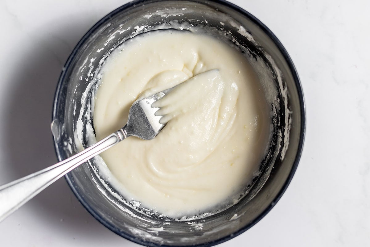 Icing for Strawberry Cinnamon Rolls in a bowl.