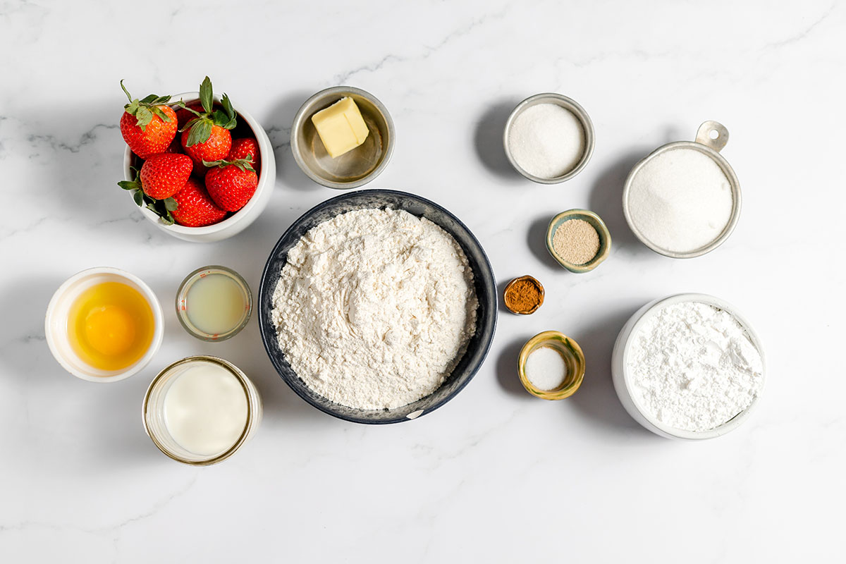 Ingredients to make strawberry cinnamon rolls set out on the counter.