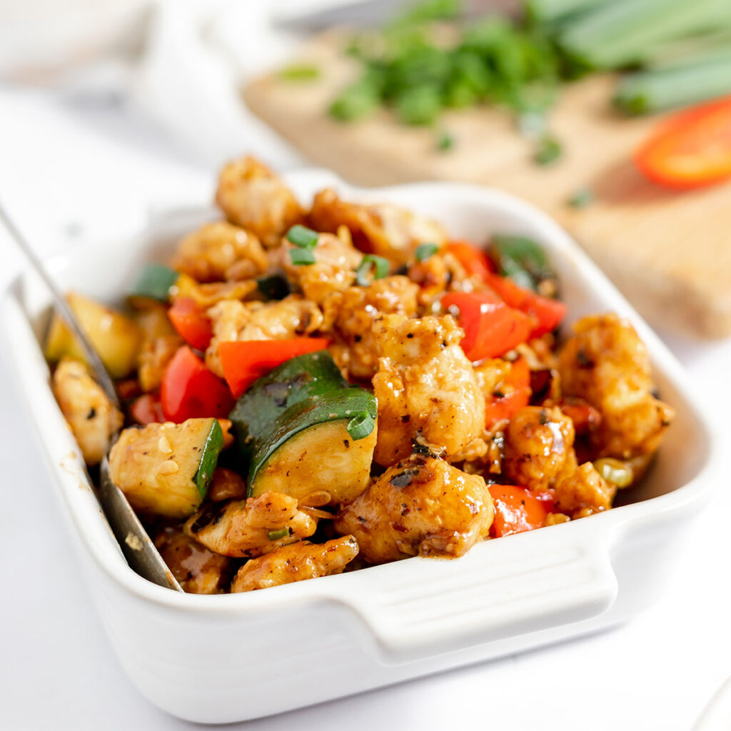 Kung Pao Chicken is served in a square white dish.
