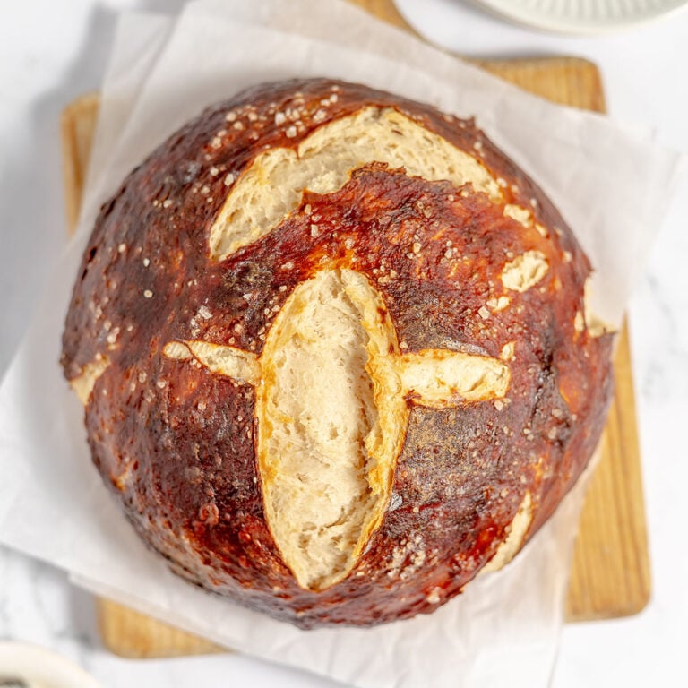 Pretzel Bread on parchment paper on a wood serving board.