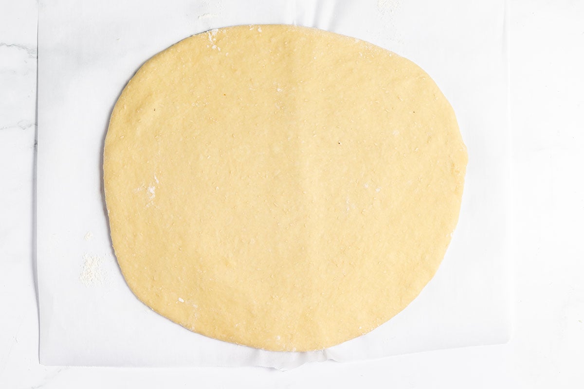 Strawberry Cinnamon Roll dough rolled out on parchment paper.