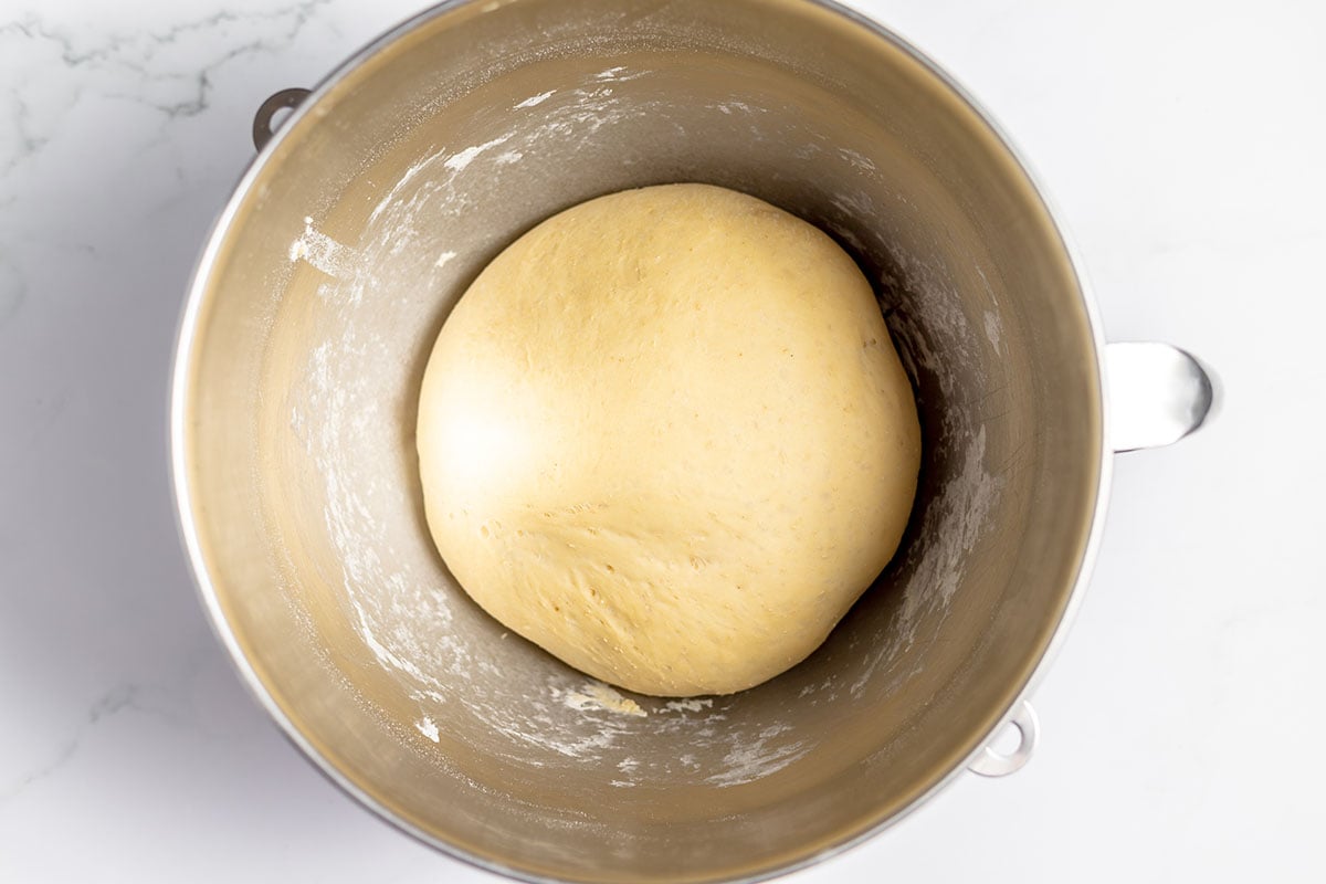 Strawberry Cinnamon Roll dough doubled in size in a stand mixer bowl.