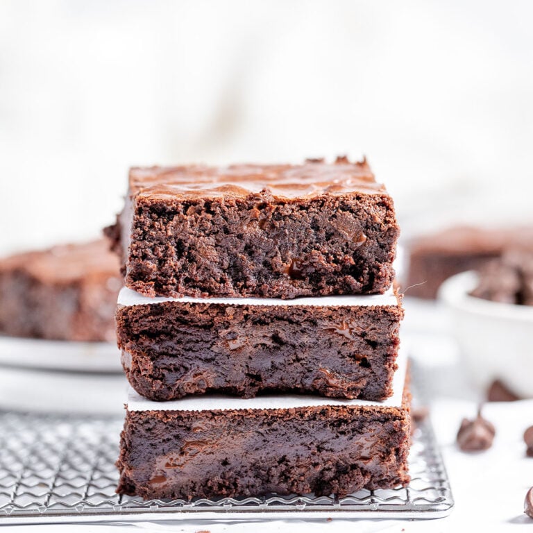 Three brownies are stacked on a wire rack.